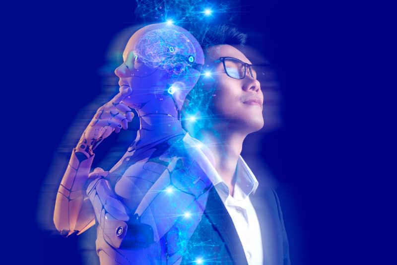 Persona y representación humanoide de inteligencia artificial juntos espalda con espalda y mirando al horizonte